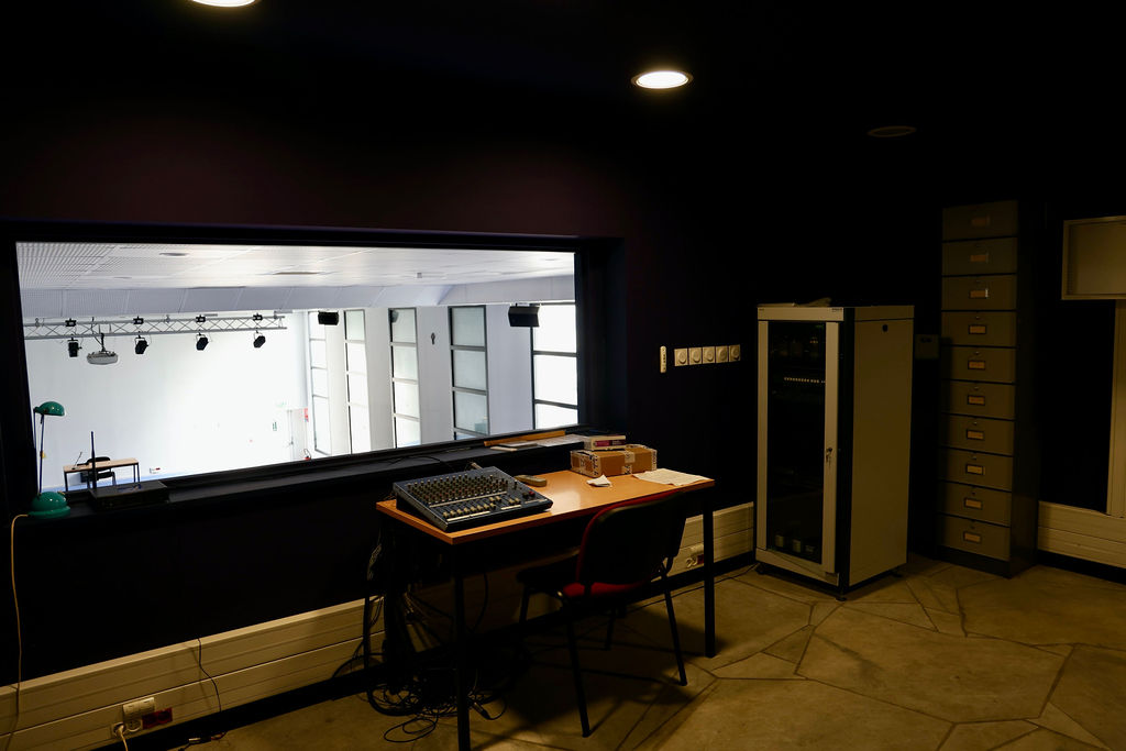 Régie technique de l’auditorium avec console et vue sur la salle